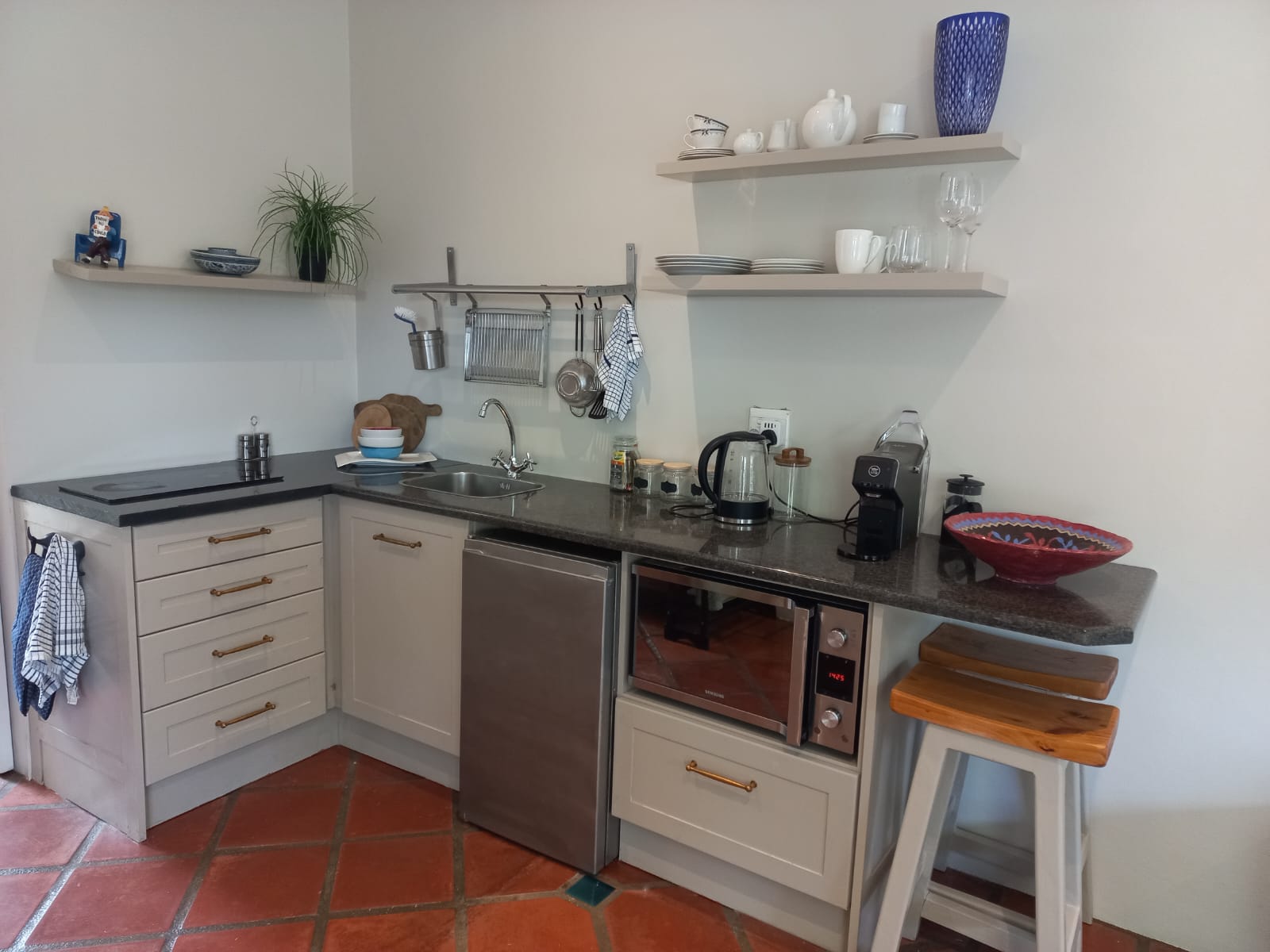 Fully equipped kitchen with oven, stovetop, and coffee machine